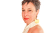 Woman wearing large gold earrings against a white background